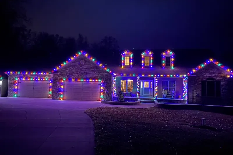 Home with multicolor lights along the gables, dormers and garage doors